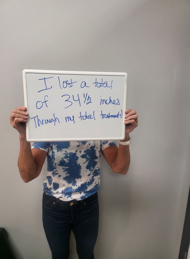 Contour Light client holding a whiteboard: 34½ inches — Total lost through full treatment series